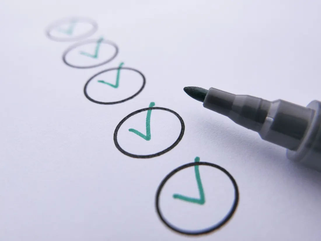 A checklist on paper with items ticked off in green marker