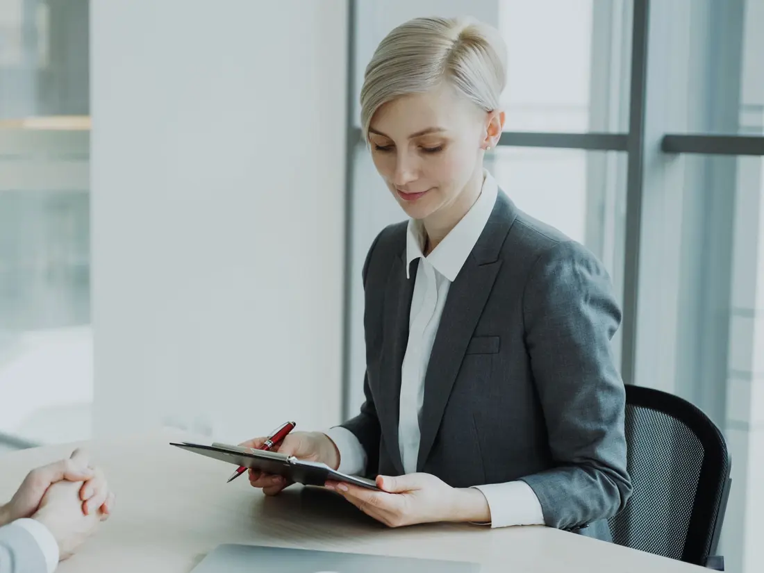 A manager in a suit reading a document across a desk